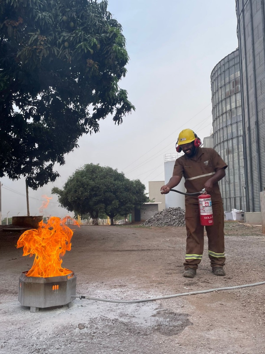 Treinamento de brigada de incêndio (NR-23): brigadista extinguindo chamas com extintor em unidade de silos